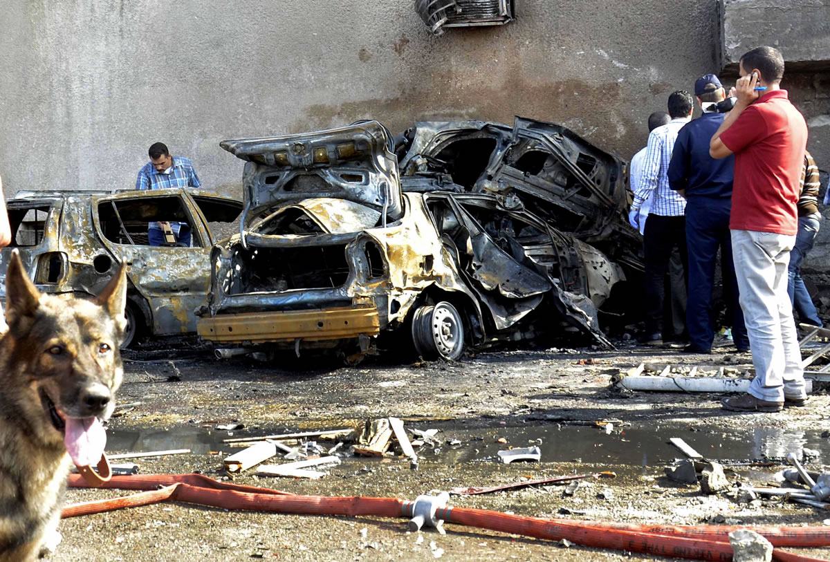 Security officials examine the site of a car bomb in the Suez Canal city of Ismailia, Egypt, Saturday Oct. 19, 2013.