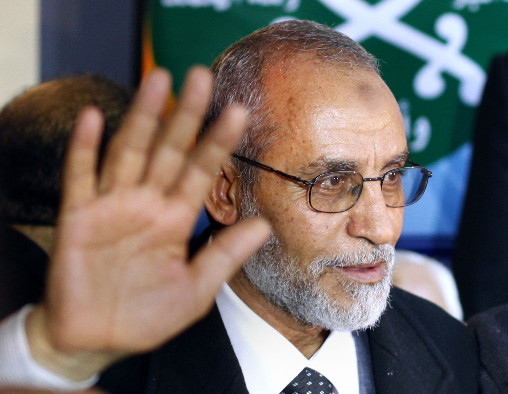 Newly elected leader of Egypt's Muslim Brotherhood Mohammed Badie stands in front of the group's logo during his first press conference in Cairo, Egypt.