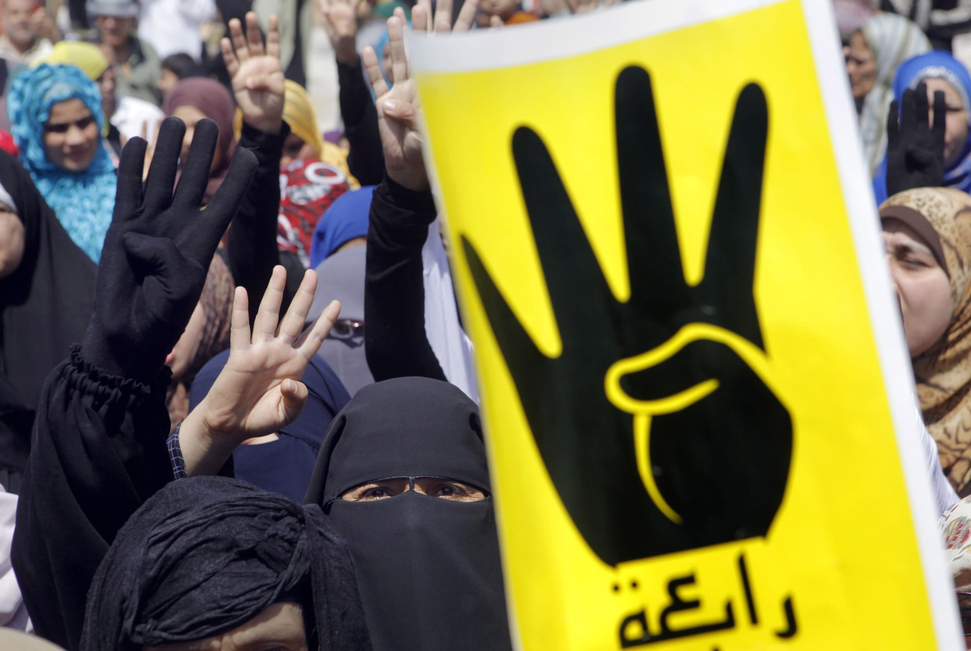 Supporters of Egypt's ousted President Mohammed Morsi raise their hands and four fingers, as a symbol of the recent massacre in Rabaah al-Adawiya mosque on Aug.