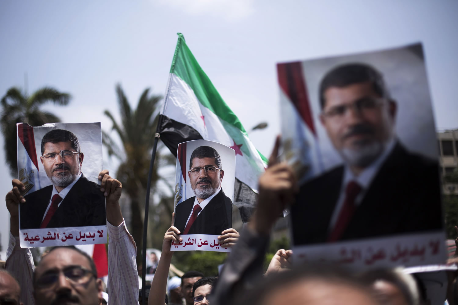 Supporters hold posters of Egypt's Islamist President Mohammed Morsi during a rally near Cairo University Square in Giza, Egypt, on Tuesday.