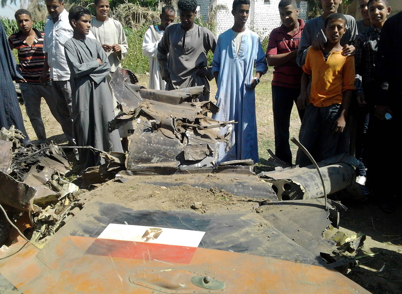 Egyptians gather around the remains of a Soviet-made MiG-21 fighter jet belonging to the Egyptian air force that crashed Sunday while on a training mission near the southern ancient city of Luxor. Officials said the crash killed a villager on the ground and injured several.