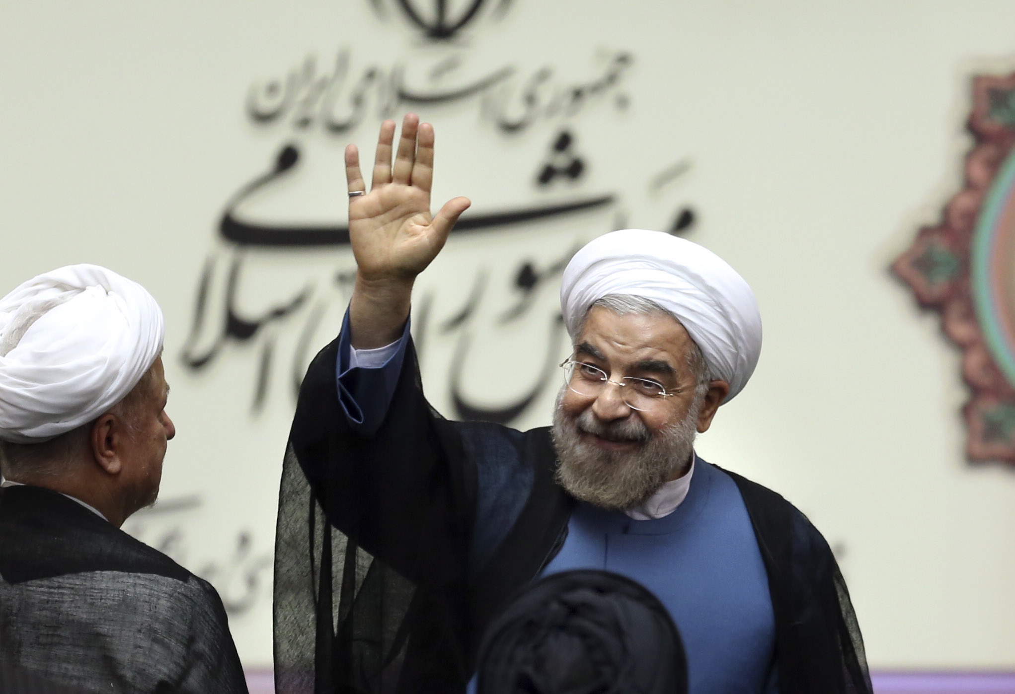 Iran's new President Hasan Rouhani waves after his swearing-in Sunday during an open session of parliament in  Tehran, Iran.