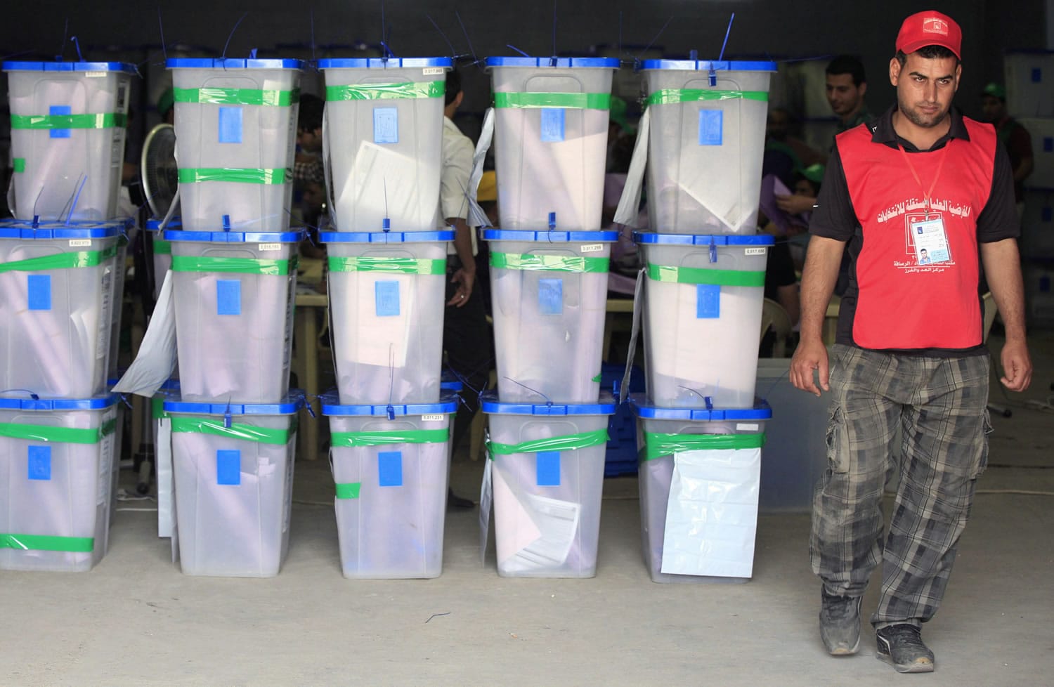 An electoral worker walks past ballot boxes at a counting center after the early voting for security forces in the country's provincial elections in Baghdad, Iraq, on Monday.