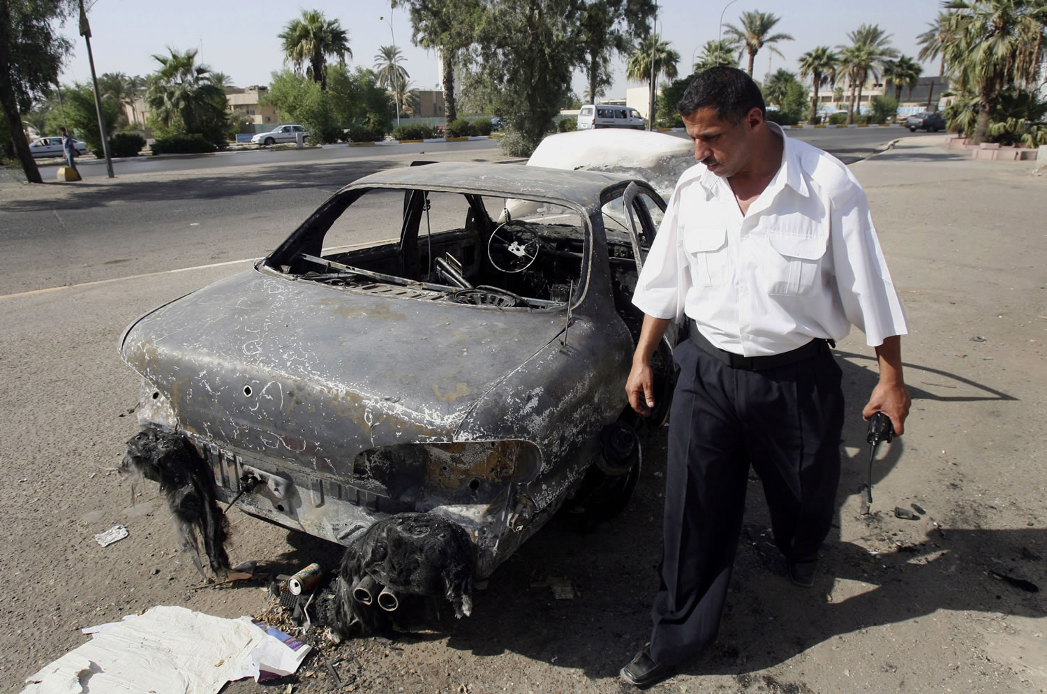 An Iraqi traffic policeman inspects a car destroyed by a Blackwater security detail in al-Nisoor Square in Baghdad, Iraq, on Sept.