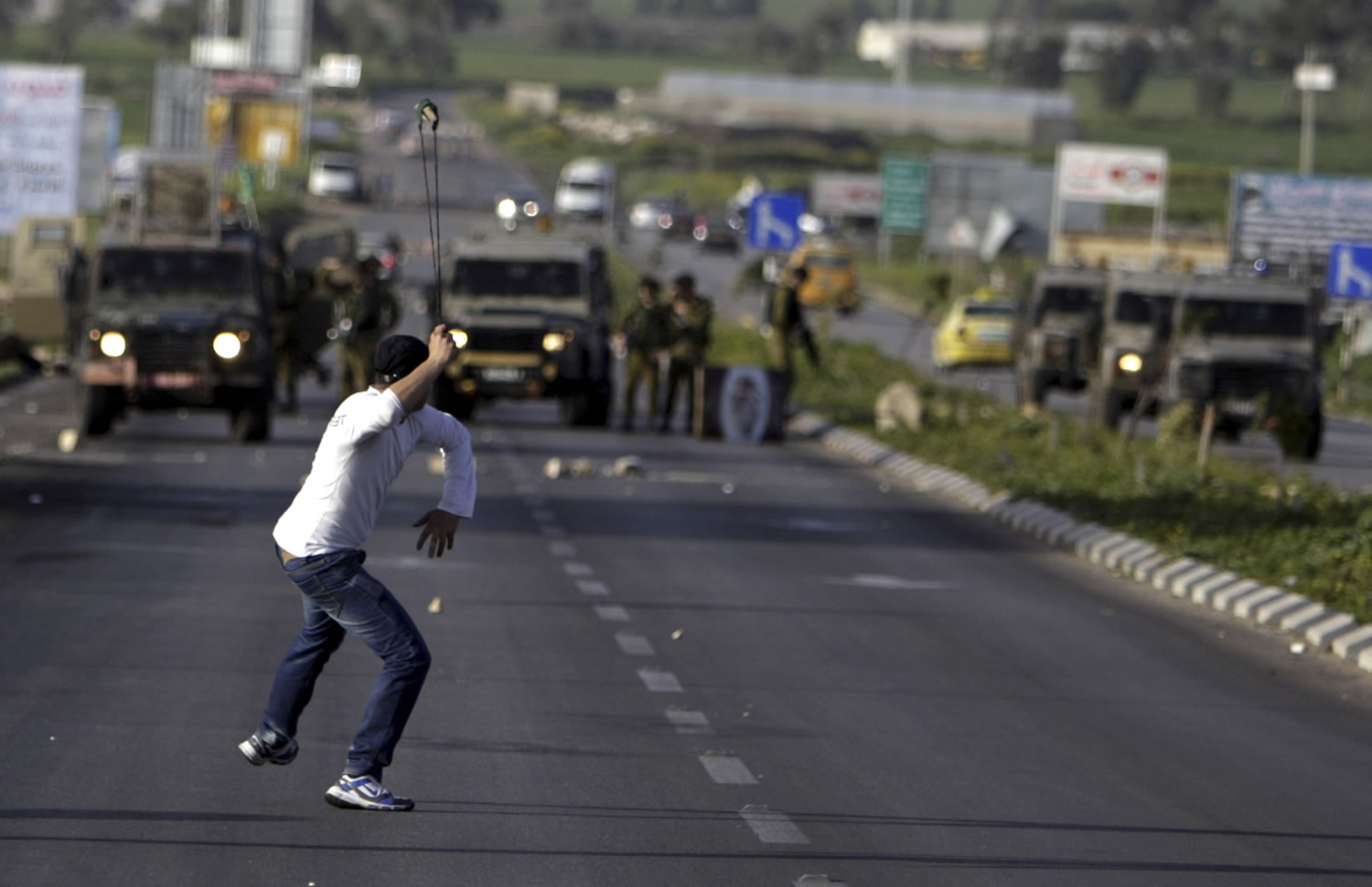 A Palestinian man throws stones Sunday at Israeli soldiers during clashes north of the West Bank city of Jenin that followed a rally in support of the Palestinian prisoners in Israeli jails.