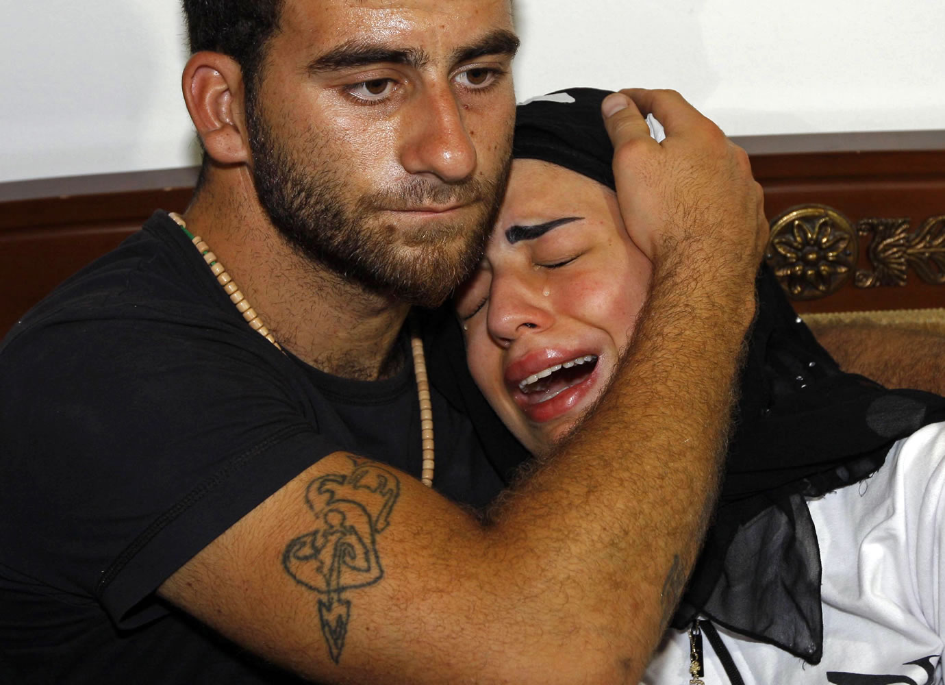 Fatima, right, daughter of Mohammed Darrar Jammo a Syrian political analyst and one of Syrian President Bashar Assad's strongest defenders, who was gunned down inside his home, is comforted by a relative as she mourns her father in the southern coastal town of Sarafand, Lebanon, on Wednesday.