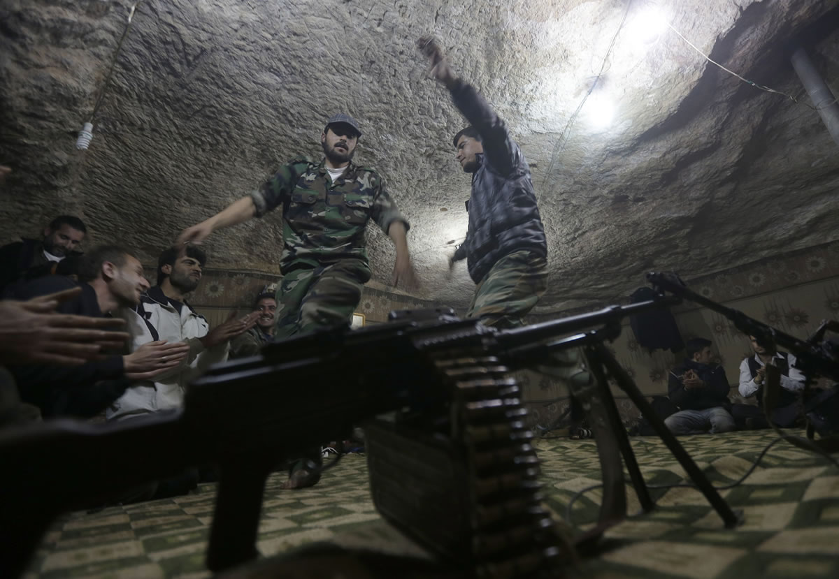 Free Syrian Army fighters perform a traditional dance as they sing songs against Syrian president Bashar Assad during a revolutionary party at one of their caves in Jabal al-Zaweya, in Idlib Province, Syria, on Monday.