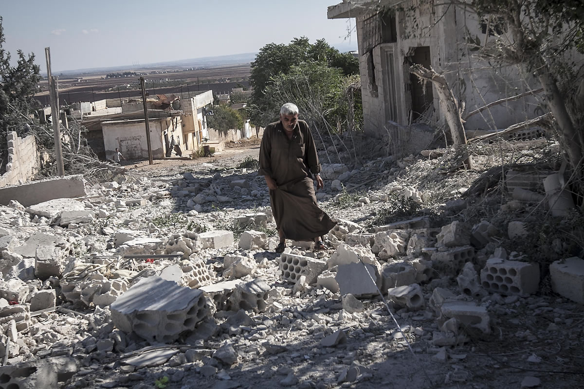 A man walks among rubble of destroyed residential buildings Wednesday, minutes after an airstrike hit Habit, Syria, in the central province of Hama.