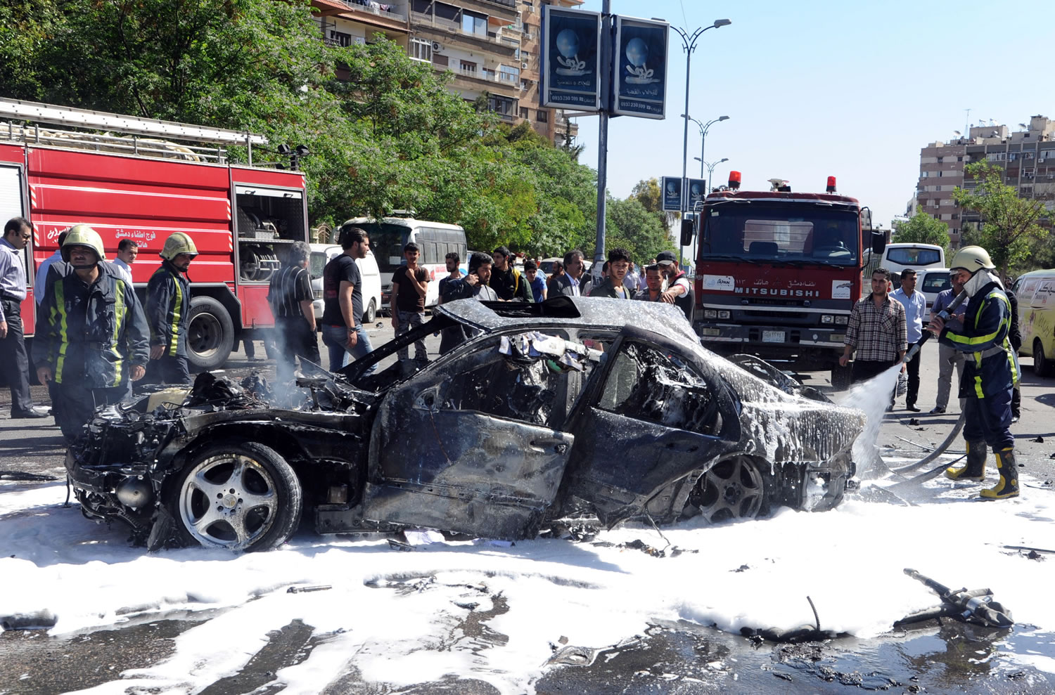 Syrian fire fighters extinguish burning cars after a car bomb exploded in the capital's western neighborhood of Mazzeh, in Damascus, Syria, on Monday.