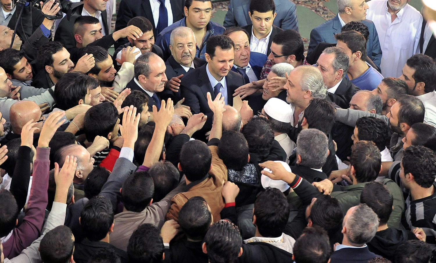 Syrian President Bashar Assad, center, greets his supporters after he attended prayers on the first day of Eid al-Adha, at the Sayeda Hassiba mosque, in Damascus, Syria, on Tuesday.
