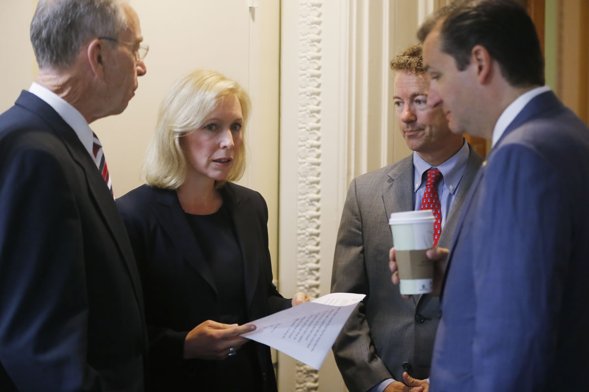 Senators Chuck Grassley, R-Iowa, from left, Kirsten Gillibrand, D-N.Y., Rand Paul, R-Ky., and Ted Cruz, R-Texas, huddle before a news conference July 16 about a bill regarding military sexual assault cases on Capitol Hill in Washington.
