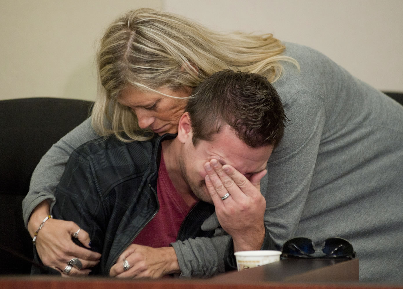Lorilei Ritmiller, mother of Whitney Heichel, hugs her son-in-law Clint Heichel on Thursday as he begins to cry after attempting to speak at a news conference in the city of Gresham, Ore., council chambers.