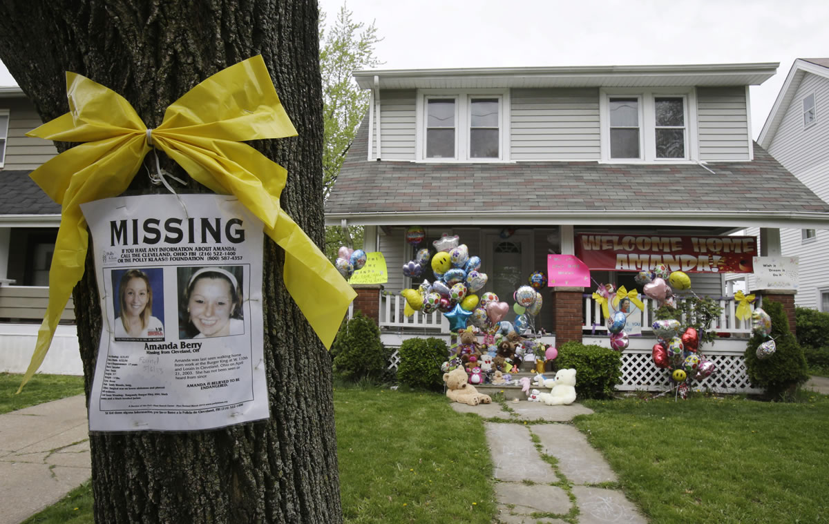 A missing poster still rests on a tree outside the home of Amanda Berry on Wednesday in Cleveland.