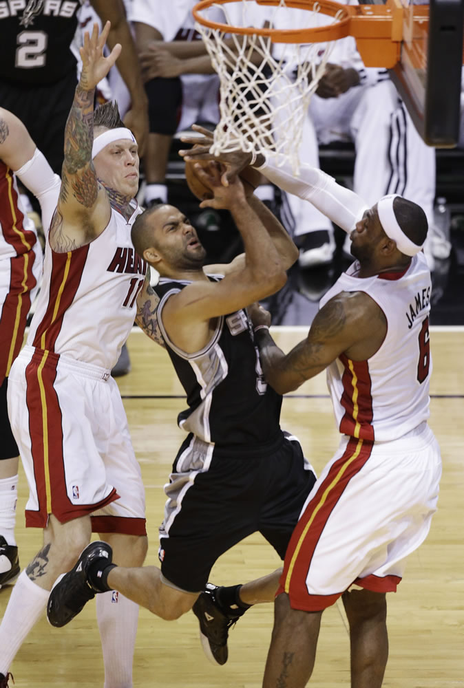 The San Antonio Spurs' Tony Parker shoots against Miami Heat's LeBron James and Chris Andersen during the first half Thursday.