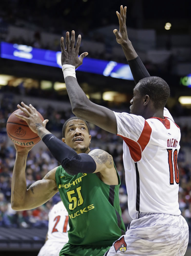 Oregon center Tony Woods (55) looks to shoot against Louisville center Gorgui Dieng (10) during the second half of the regional semifinal Friday in Indianapolis.