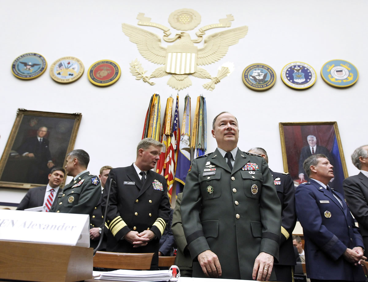Army Gen. Keith B. Alexander, then-commander of the U.S. Cyber Command, center right, arrives at a Capitol Hill committee hearing in Washington to testify about cyberspace operations in 2010.