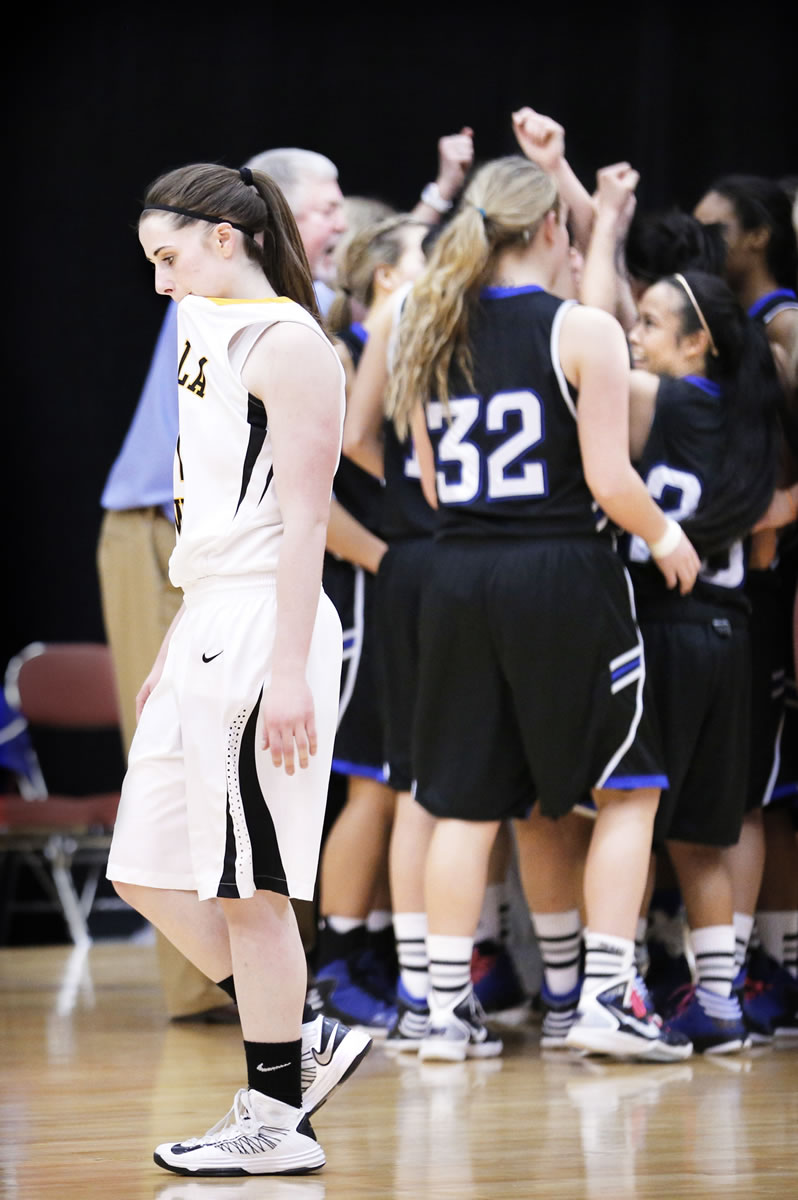 The Clark College women's basketball team celebrates in the background as Walla Walla's Michelle Seitz leaves the court at the Toyota Center in Kennewick.