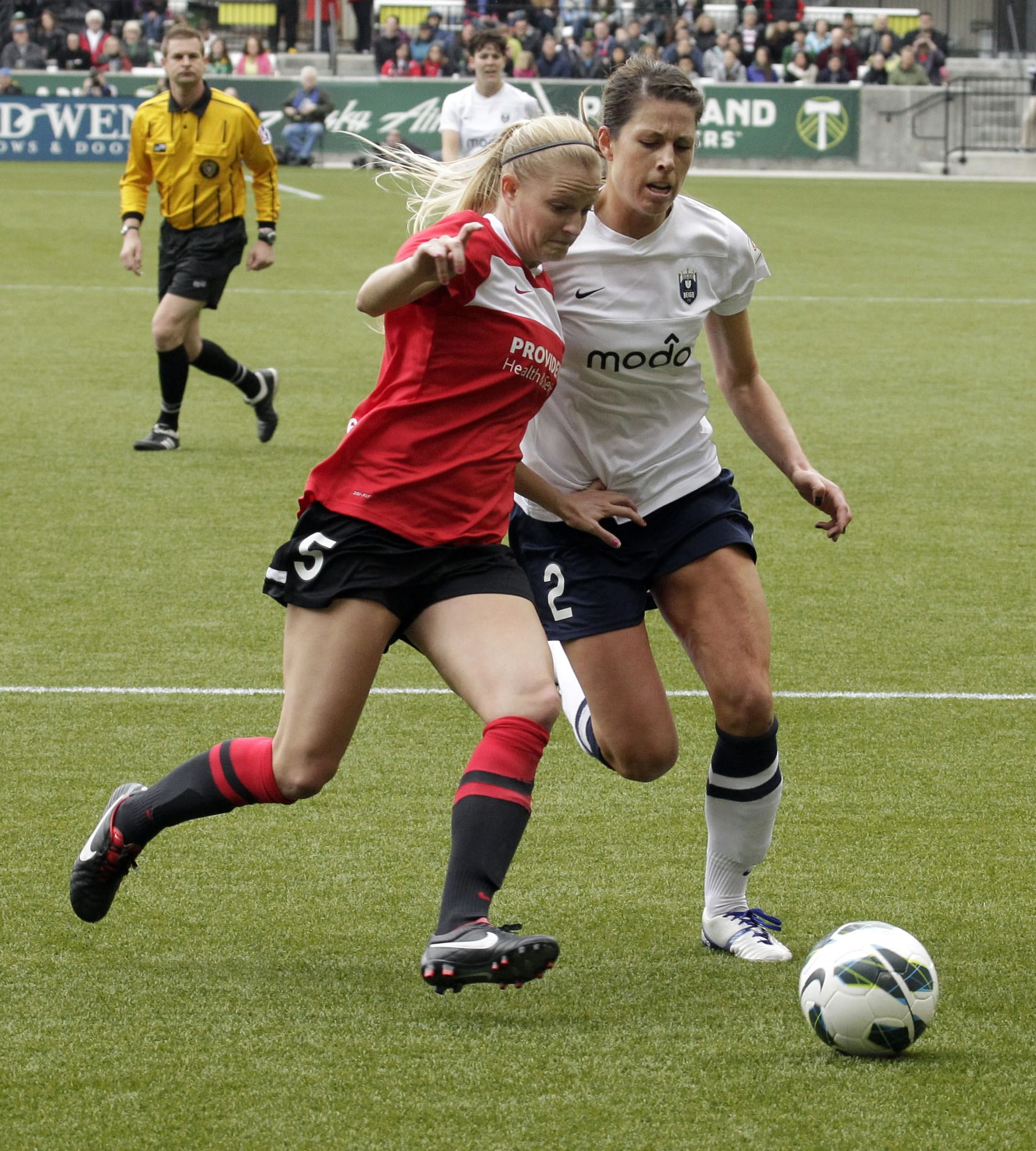 Portland Thorns defender Kathryn Williamson, left, battles for the ball with Seattle Reign defender Emily Zurrer during the first half Sunday.