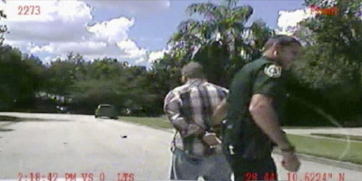 In this still image made from dash-cam video provided by the Lake Mary (Fla.) Police, George Zimmerman is detained by officers on Monday.
