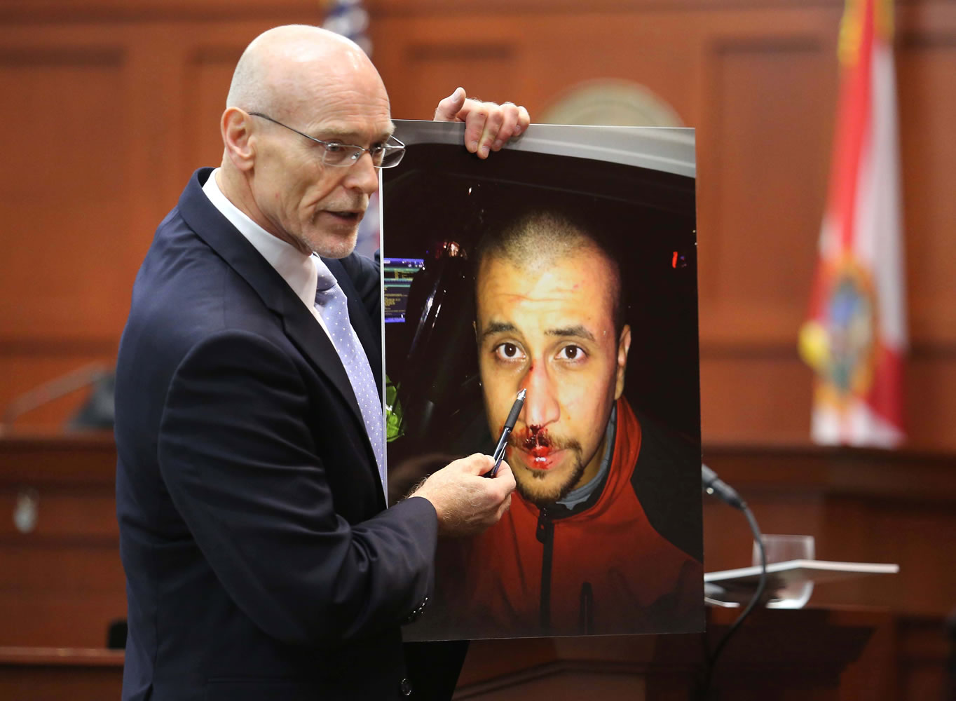 Don West, a defense attorney for George Zimmerman, displays a photo of his client from the night of the shooting of Trayvon Martin, to the jury during opening statements in Zimmerman's trial, in Seminole circuit court in Sanford, Fla., on Monday.