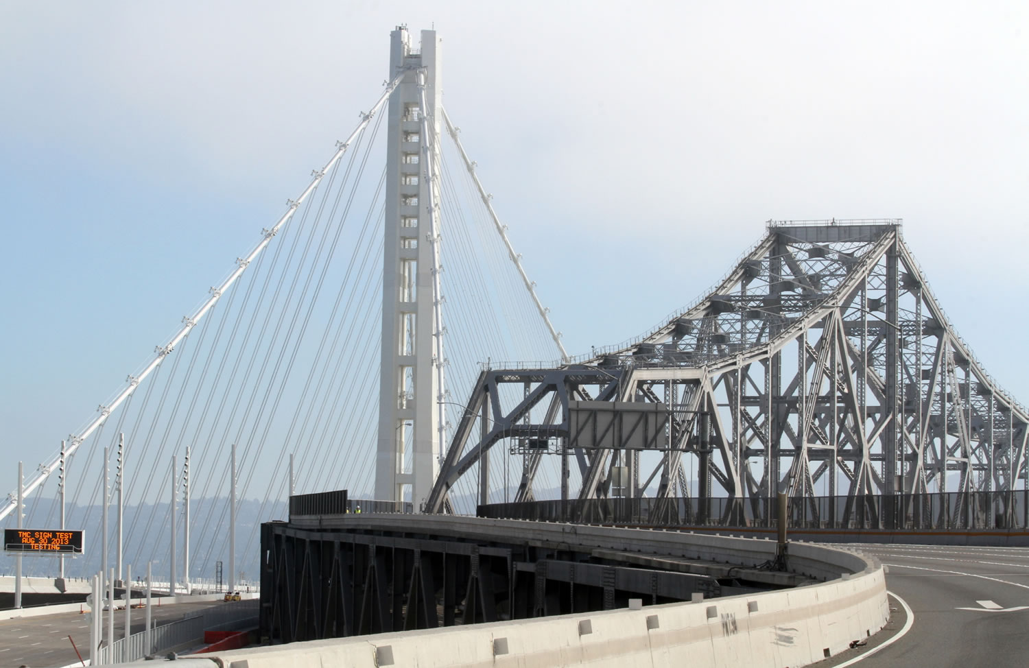 The old, right, and the new Bay bridges come together Friday during the bridge closure in Oakland, Calif.