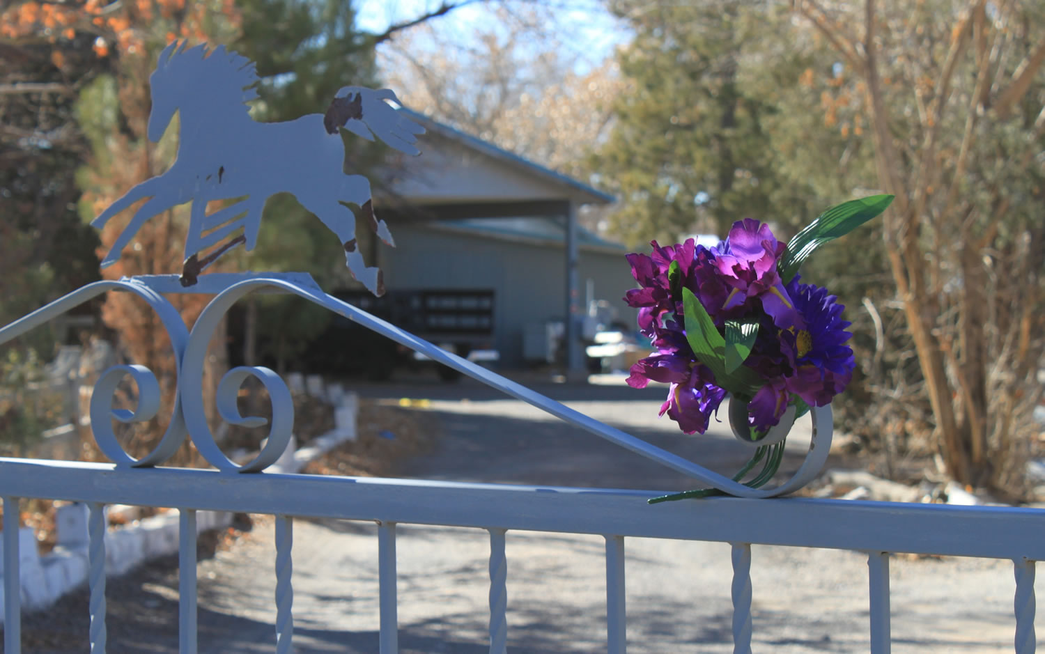 A bouquet of flowers adorns the entrance to a home on Monday where a couple and their three youngest children were found shot to death Saturday south of Albuquerque, N.M.