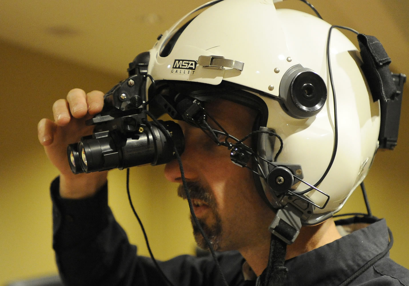 Jared Douglas, assistant chief flight instructor at Leading Edge Aviation, makes adjustments to his night-vision goggles prior to a flight June 11 at Bend Municipal Airport.