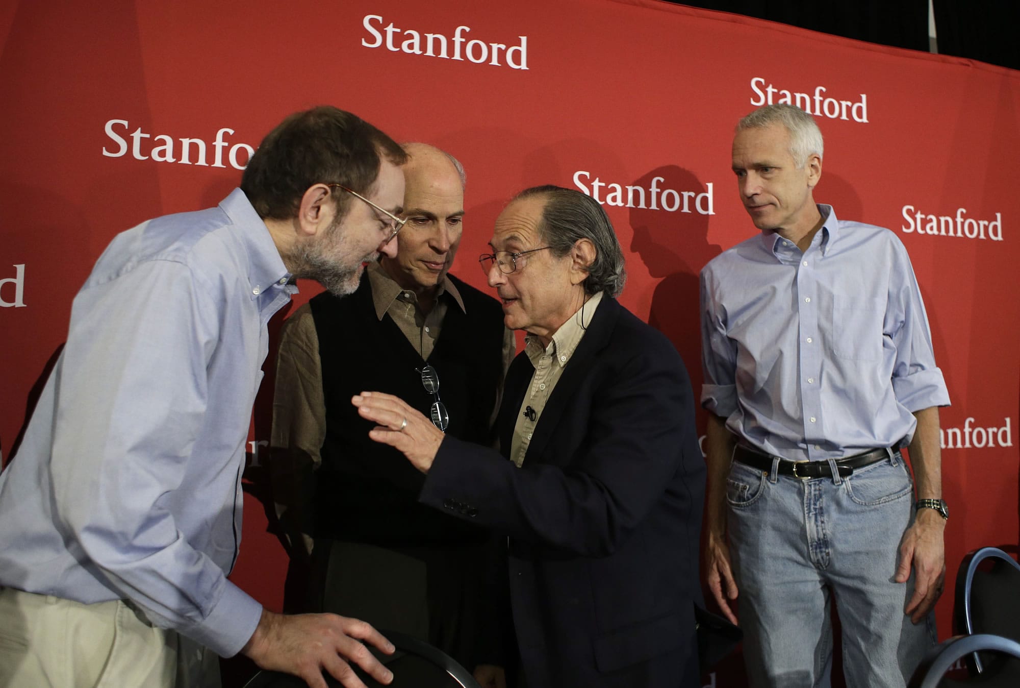 Michael Levitt, third from left, a professor at Stanford University who won the 2013 Nobel Prize in chemistry, talks with fellow Stanford Nobel laureates Andrew Fire, left, Roger Kornberg, second from left, as Brian Kobilka, right, looks on following a news conference Wednesday, in Stanford, Calif.