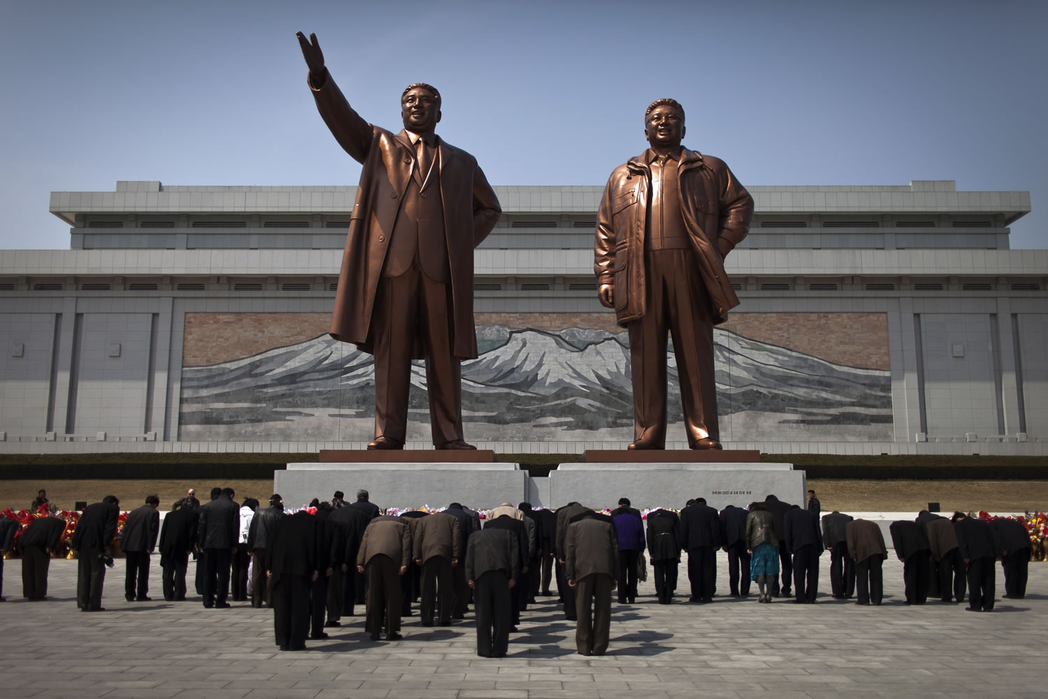 People bow to statues of North Korea's late leaders Kim Il Sung, left, and Kim Jong Il on Saturday in Pyongyang, North Korea.