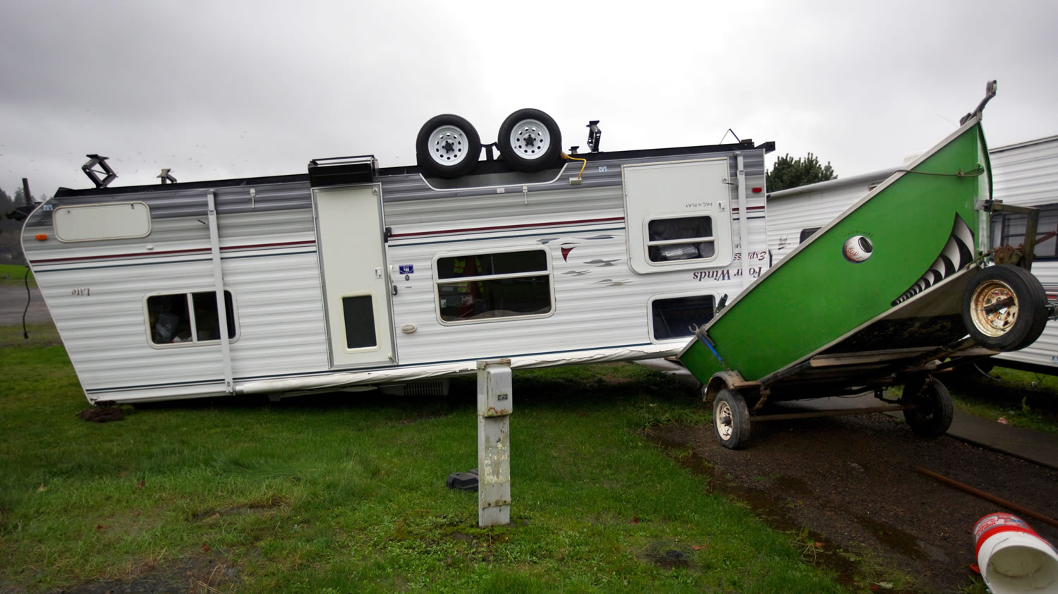 A camp trailer is left upside down at the Old Mill Marina trailer park in Garibaldi, Ore., after high winds and rain hit the Oregon Coast on Monday