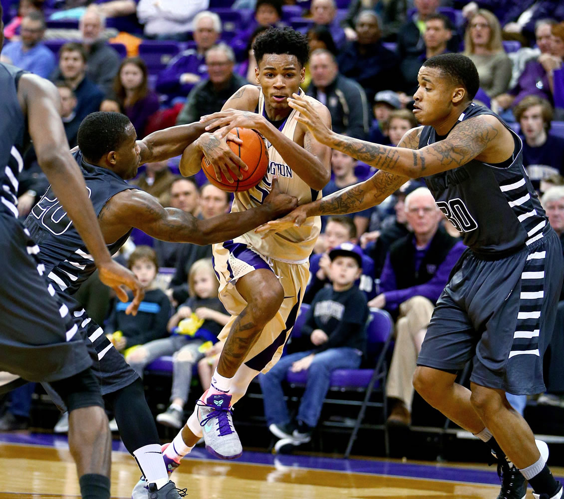 Washington's Dejounte Murray, center, is pressured by Oakland's Kay Felder, left, and Sherron Dorsey-Walker during an NCAA college basketball game Saturday, Dec. 19, 2015, in Seattle. Oakland won 97-83.
