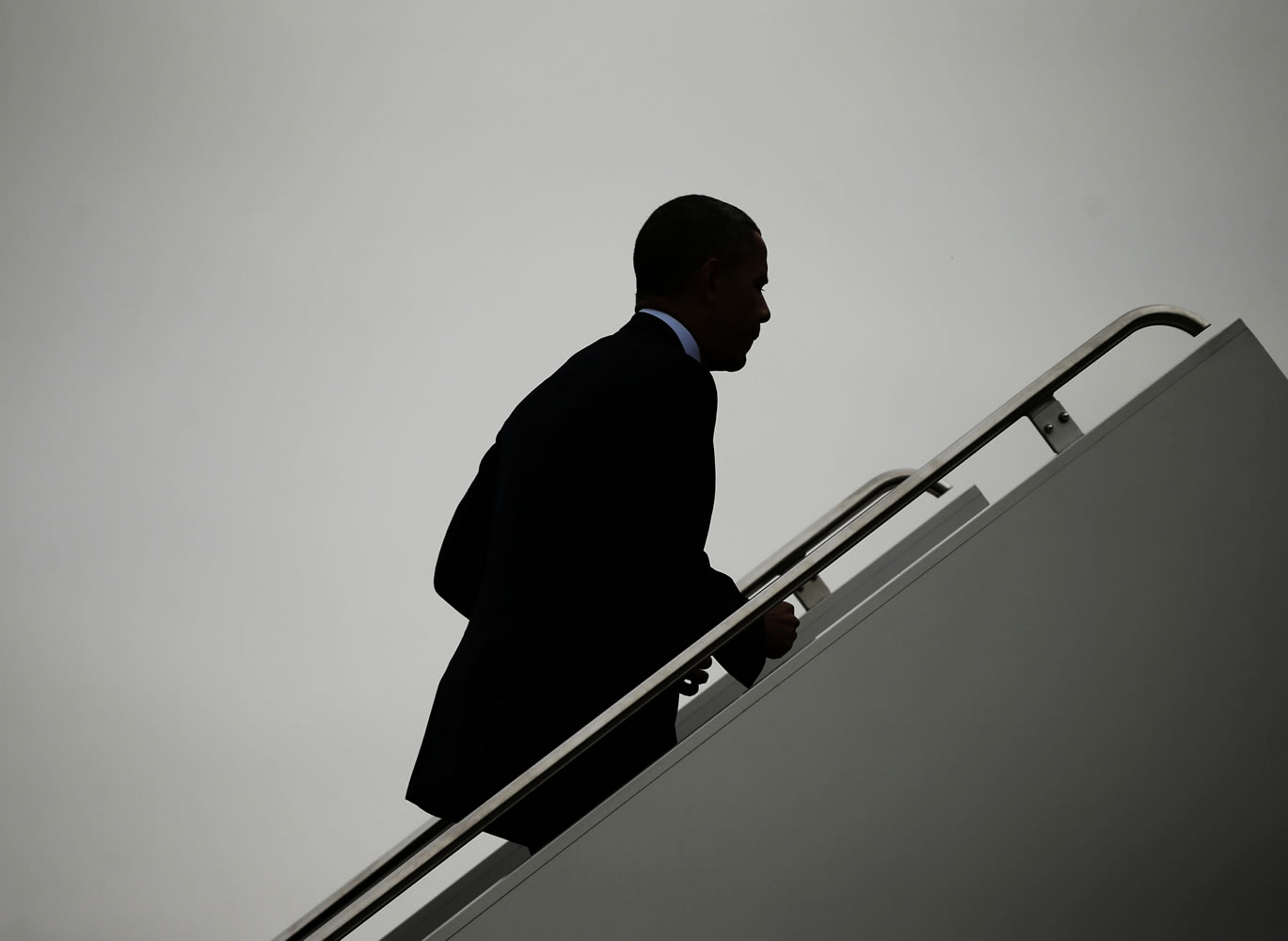 President Barack Obama is seen silhouetted as he walks up the stairs to board Air Force One before his departure from Andrews Air Force Base on Thursday.