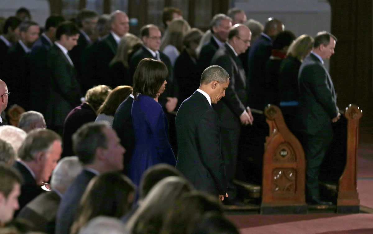 President Barack Obama and first lady Michelle Obama stand in prayer during an interfaith healing service at the Cathedral of the Holy Cross in Boston on Thursday for victims of Monday's Boston Marathon explosions.