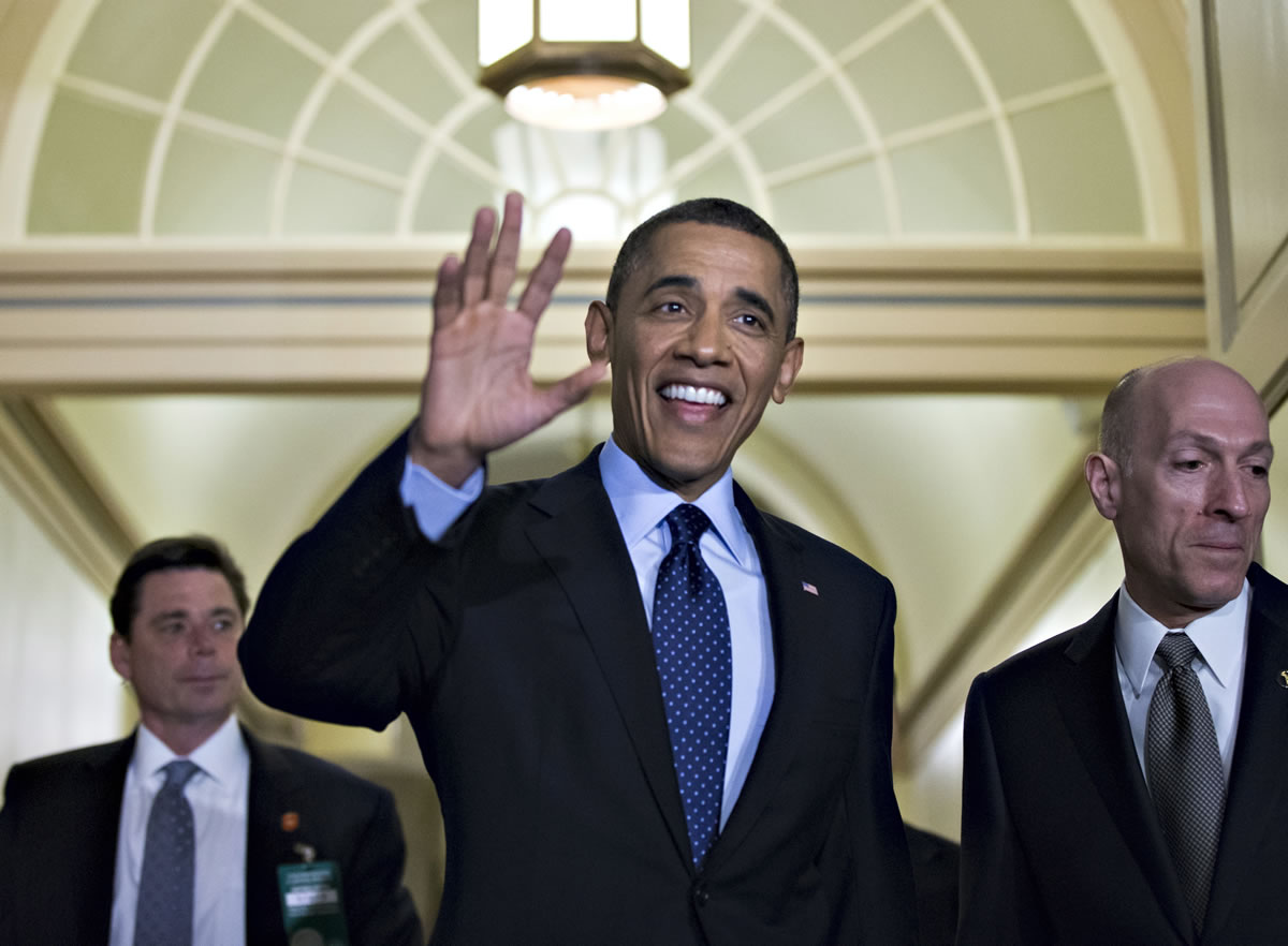 President Barack Obama, escorted by House Sergeant at Arms Paul Irving, right, waves as he arrives on Capitol Hill in Washington on Wednesday for closed-door talks with House Speaker John Boehner and the House Republican Conference to discuss the budget.