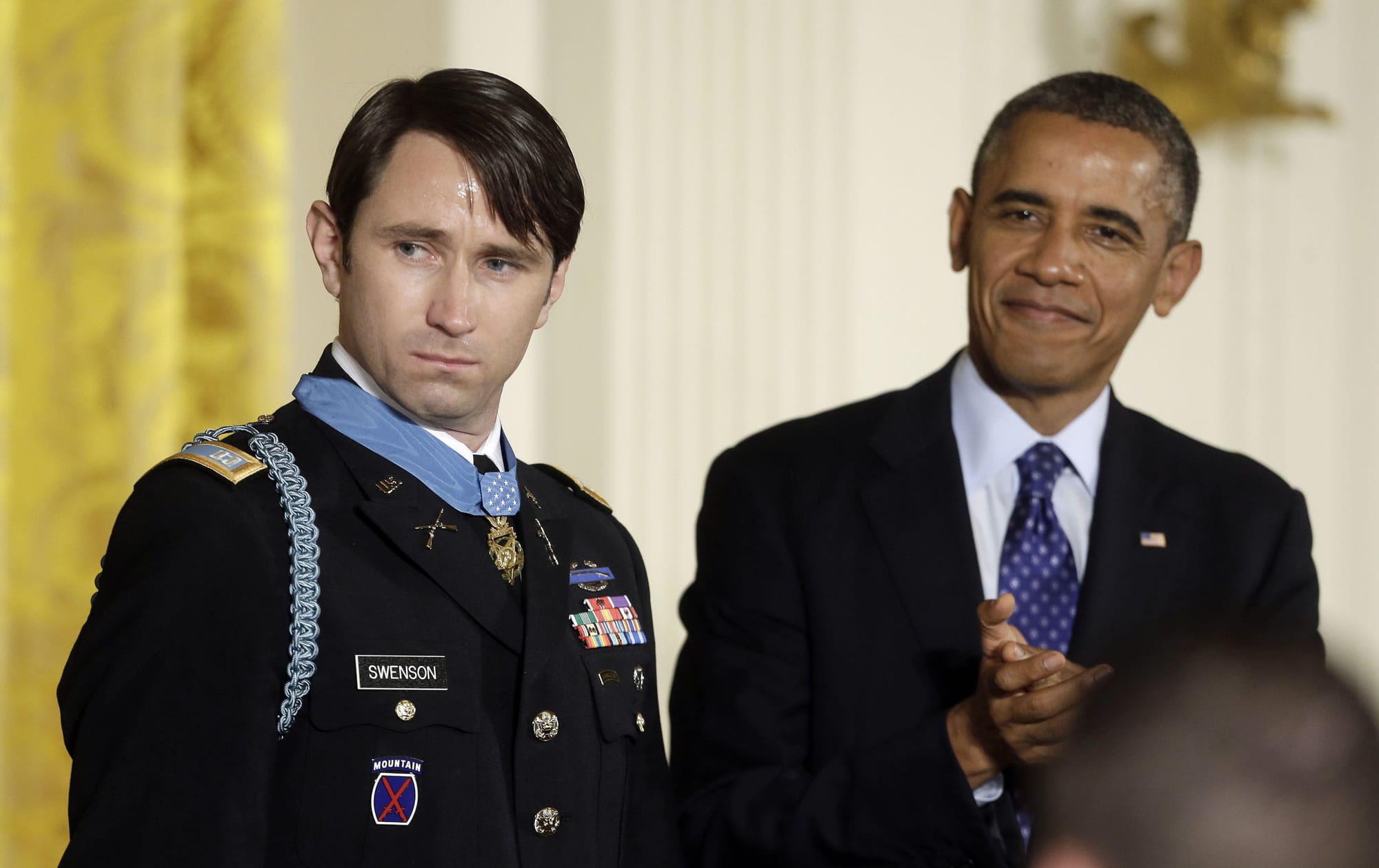 President Barack Obama, right, applauds after awarding the Medal of Honor to former Army Capt. William D.