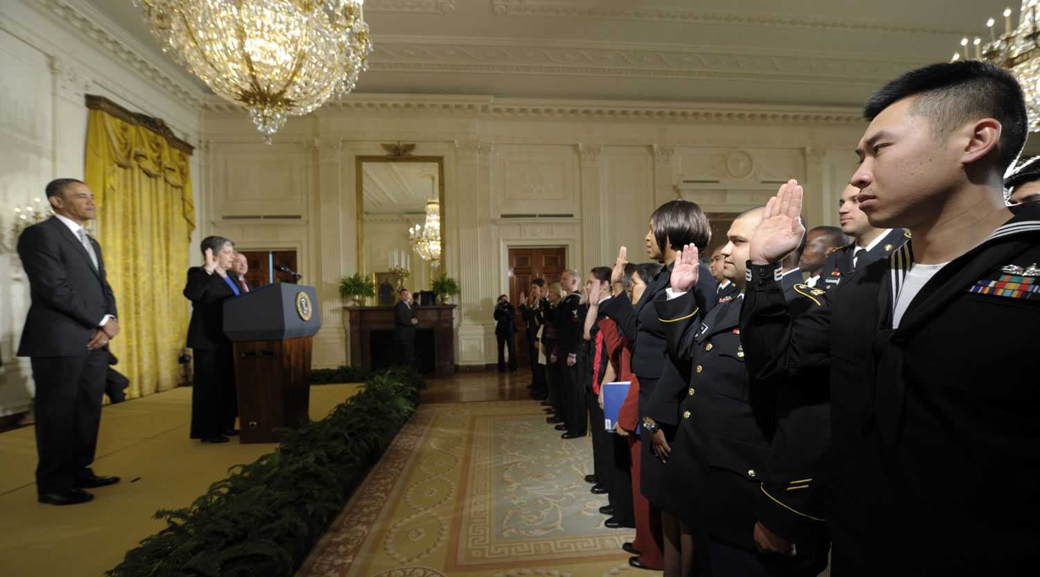 President Barack Obama listens as Homeland Security Secretary Janet Napolitano delivers the oath of allegiance during a naturalization ceremony for active duty service members and civilians, on Monday in the East Room of the White House in Washington.