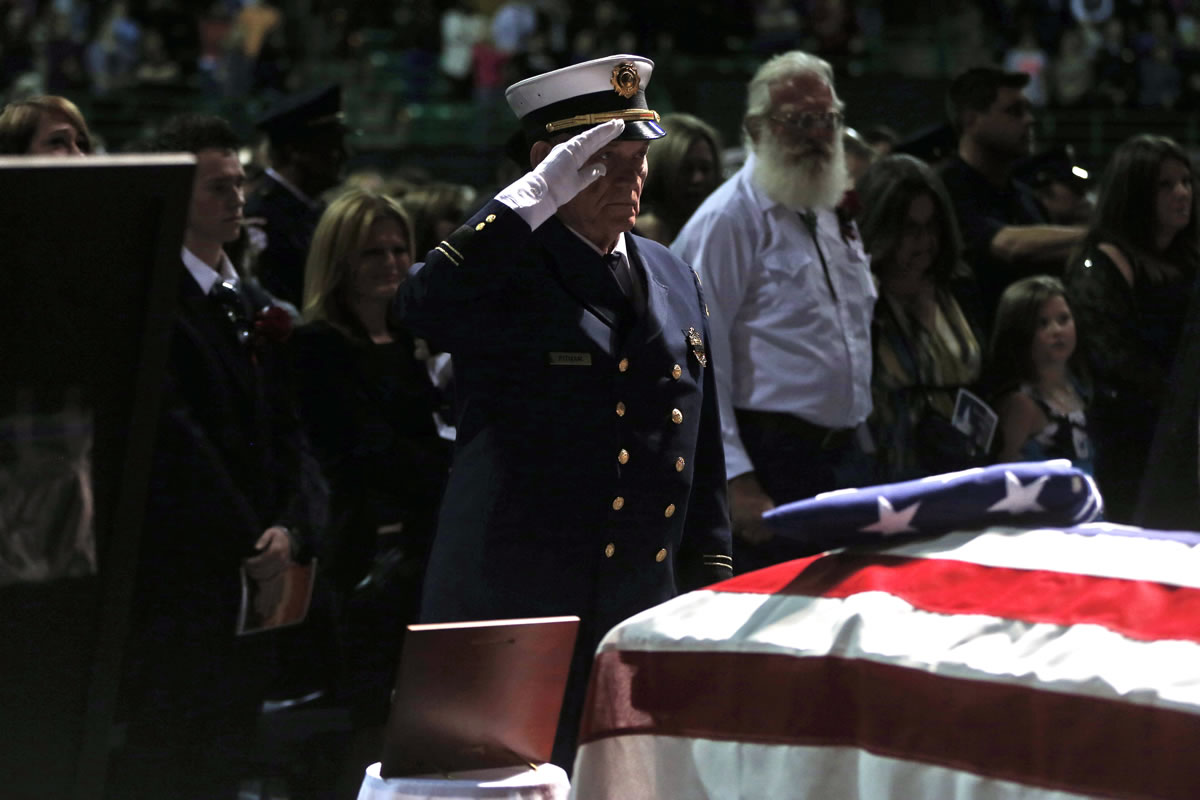 An honor guard member salutes Thursday at the memorial for firefighters killed at the fertilizer plant explosion in West, Texas, at Baylor University in Waco, Texas.