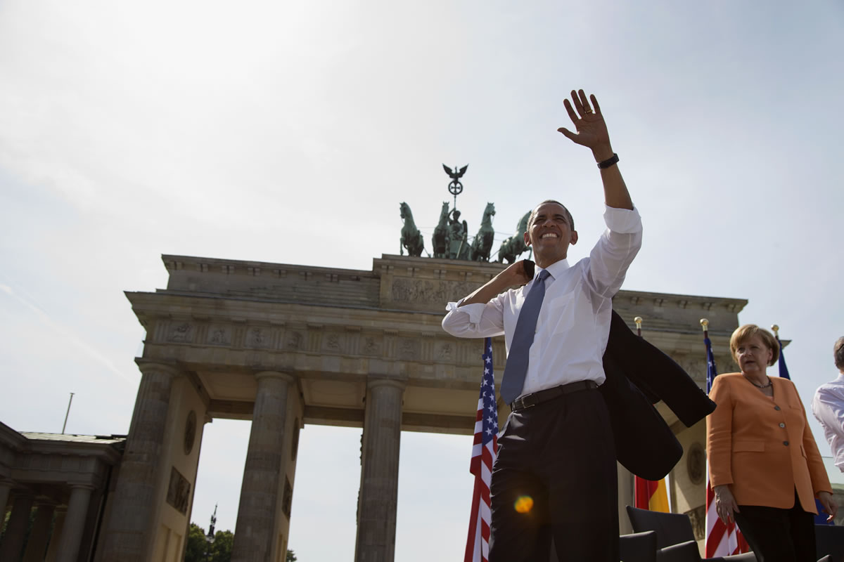 President Barack Obama, accompanied by German Chancellor Angela Merkel, waves to the crowd after speaking at the Brandenburg Gate in Berlin on Wednesday. Obama called to reduce the world's nuclear stockpiles, including a proposed one-third reduction in U.S.