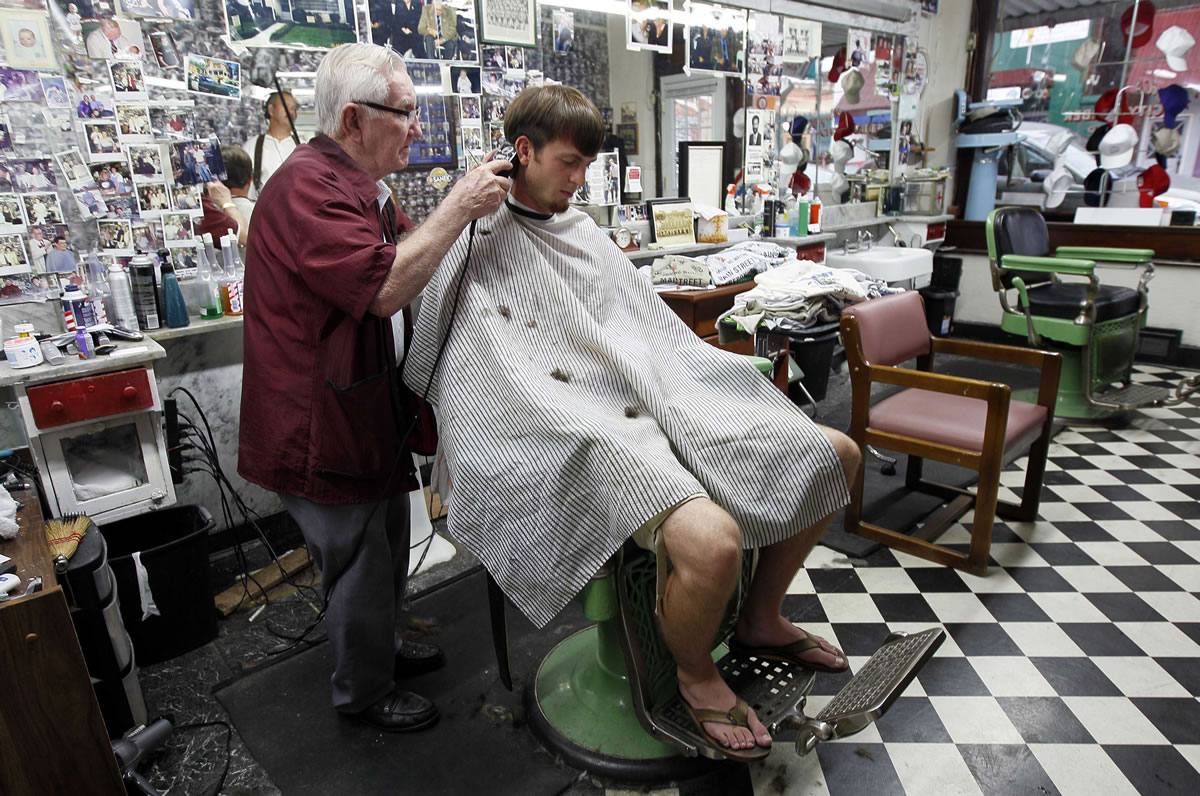 Barber Russell Hiatt, known locally as Floyd, cuts Ethan Boles' hair at Floyd's City Barber Shop in Mount Airy, N.C.