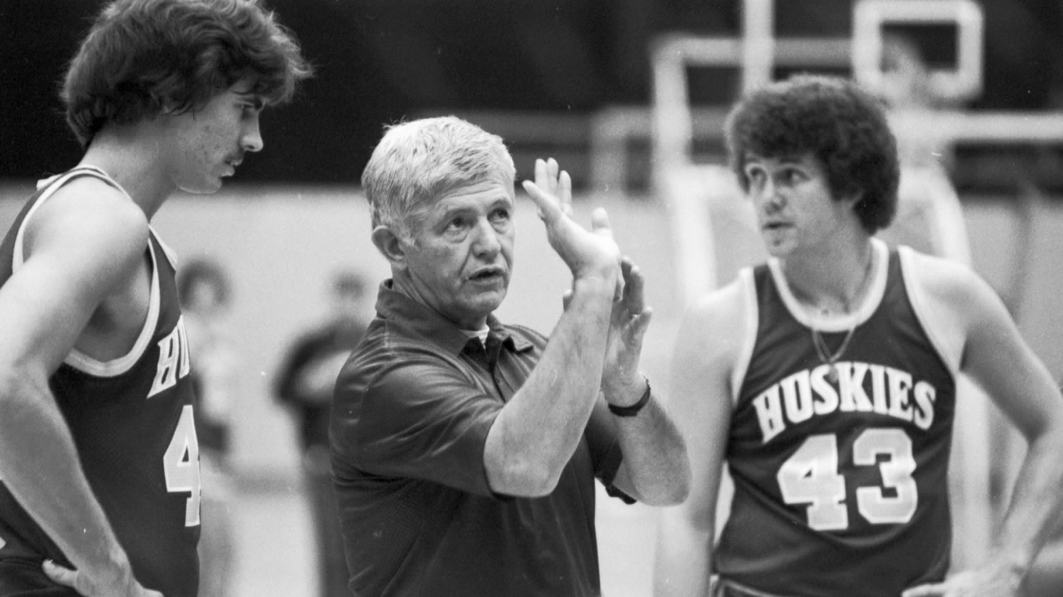 In this Oct. 13, 1977, file photo, Washington coach Marv Harshman shows Scott Hartman, left, how to hold the ball when shooting as Kim Stewart, right, looks on, during a practice session in Seattle. Harshman, who spent 40 years coaching in the state of Washington, died Friday, April 12, 2013.