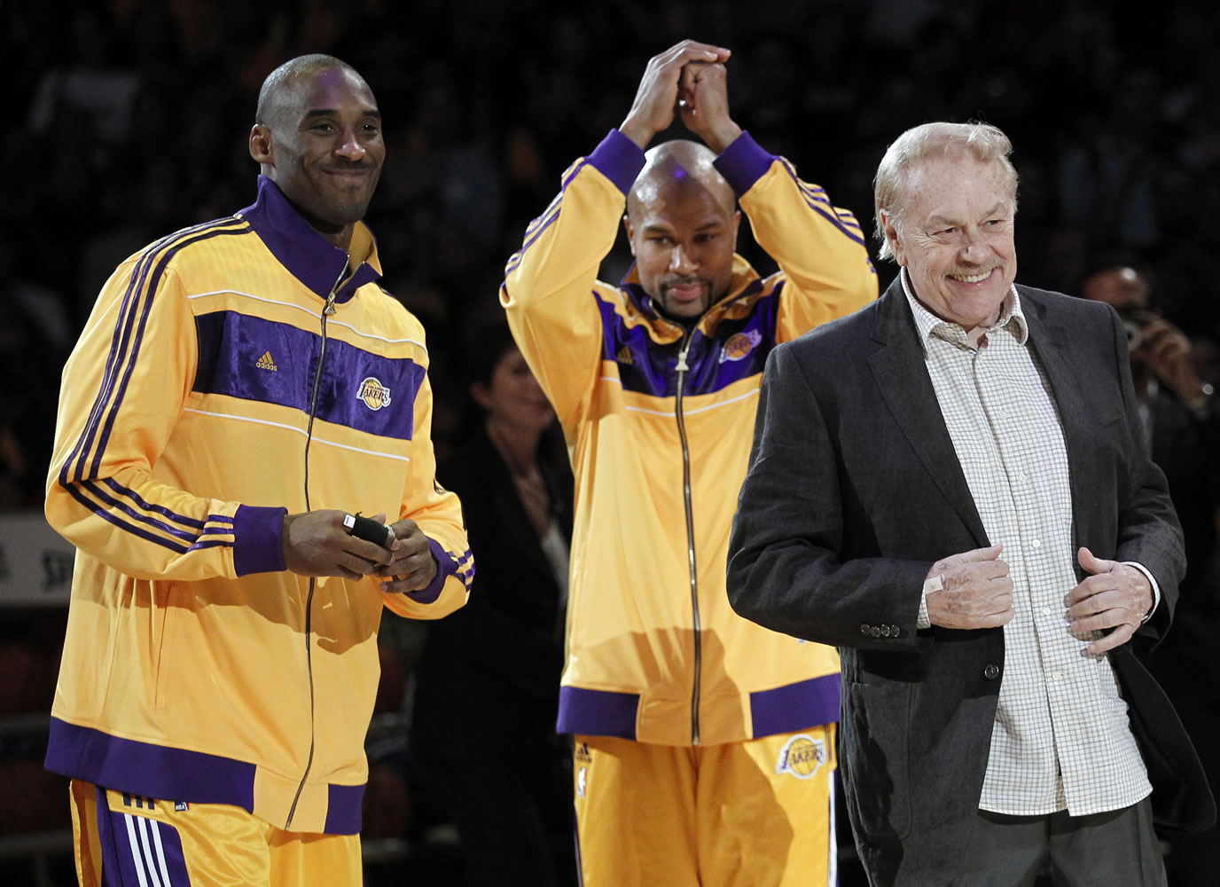 Los Angeles Laker owner Jerry Buss, right, walks out onto the court on Oct. 26, 2010, during the NBA championship ring ceremony as Kobe Bryant, left, and Derek Fisher look on before a basketball game against the Houston Rockets in Los Angeles. Buss, the Lakers' playboy owner who shepherded the NBA franchise to 10 championships, has died.