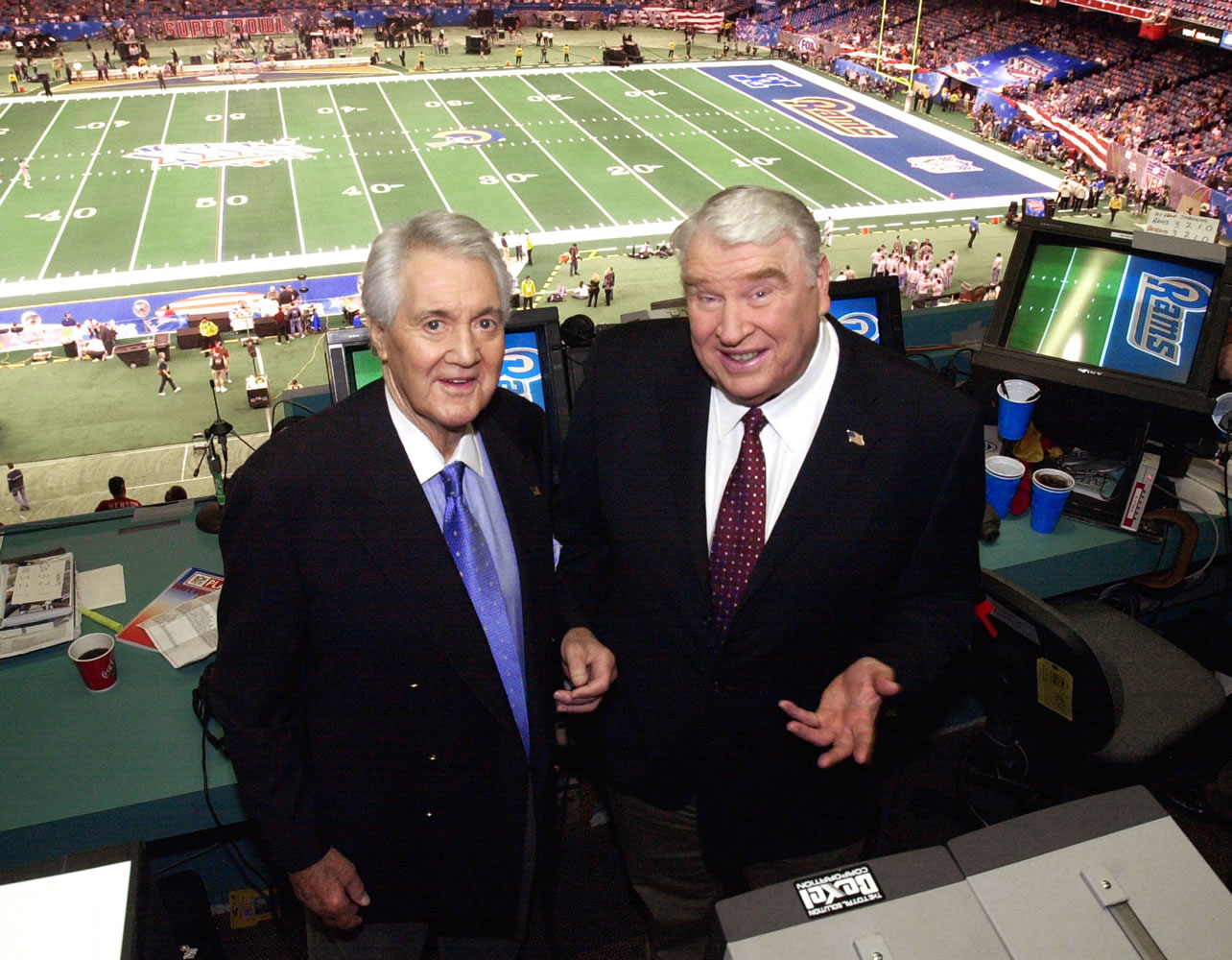 Fox broadcasters Pat Summerall, left, and John Madden stand in the booth at Louisiana Superdome before the NFL Super Bowl XXXVI football game in New Orleans in 2002.