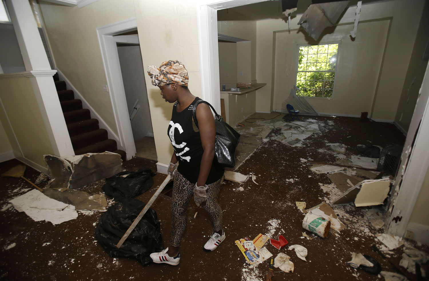 Sanautica Hicks-Ross, 18, searches an abandoned home Sunday near where three bodies were found in East Cleveland, Ohio. Hicks-Ross is an East Cleveland resident.