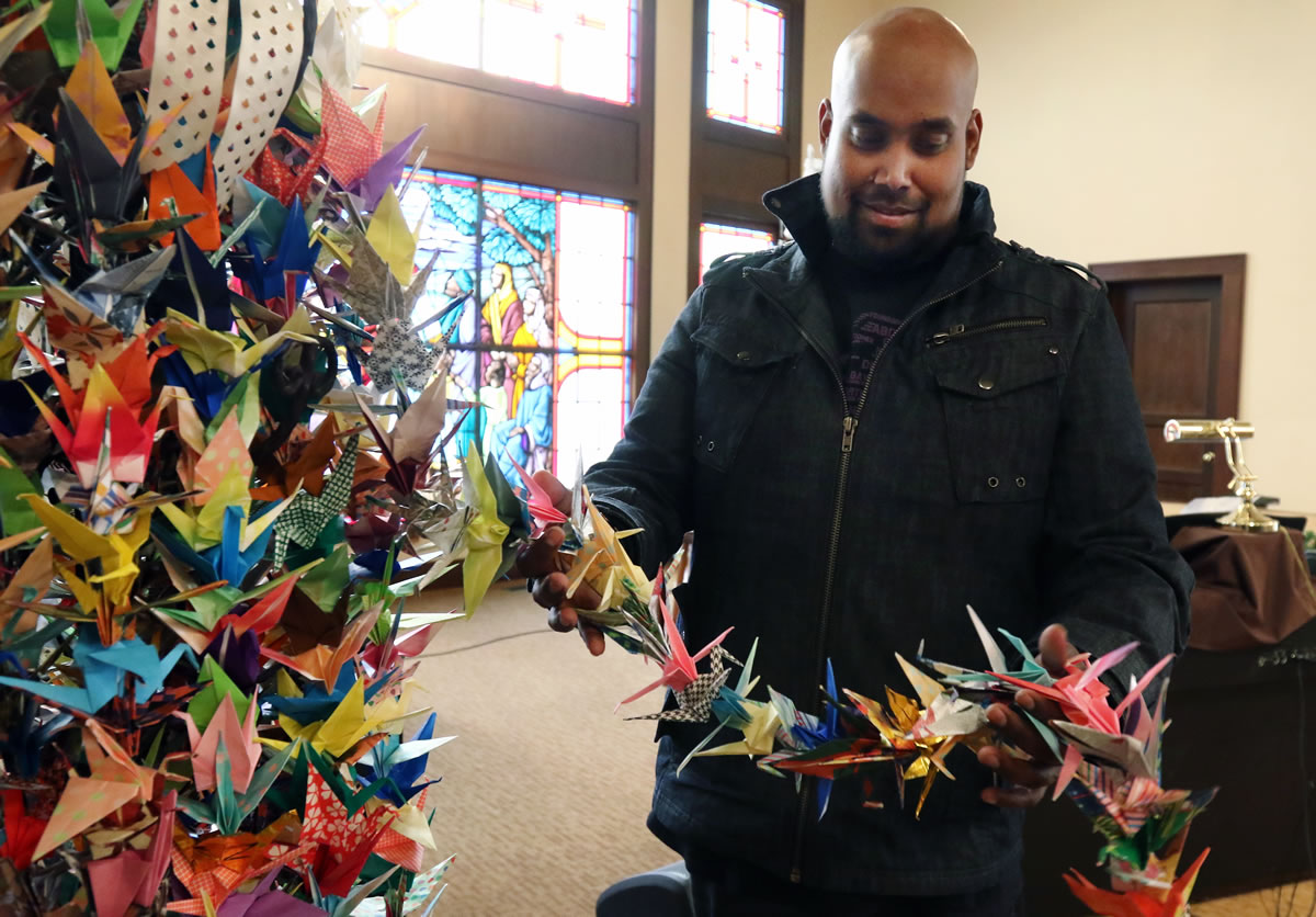 The Rev. Daniel Mallipudi, pastor of First Christian Church in Roseburg, Ore., holds a string of origami cranes displayed at the church. The cranes, 1,000 in all, were folded by members of the First Congregational Church of Santa Barbara, Calif., and sent as symbols of peace and support following the mass shooting at Umpqua Community College on Oct. 1.
