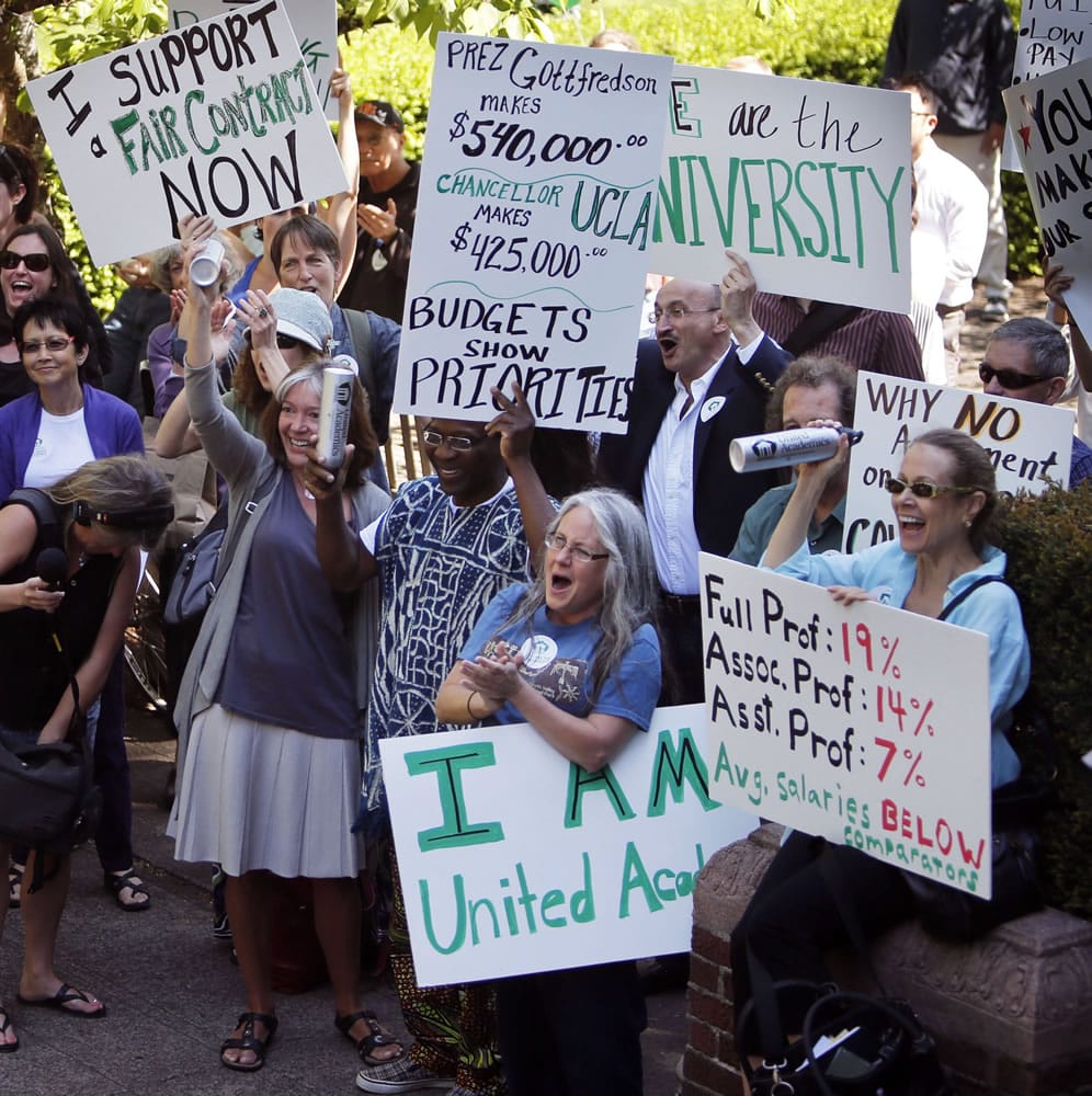 University of Oregon professors, instructors and their supporters rally on the steps of the Knight Library of the University of Oregon in favor of a new contract Tuesday in Eugene, Ore.