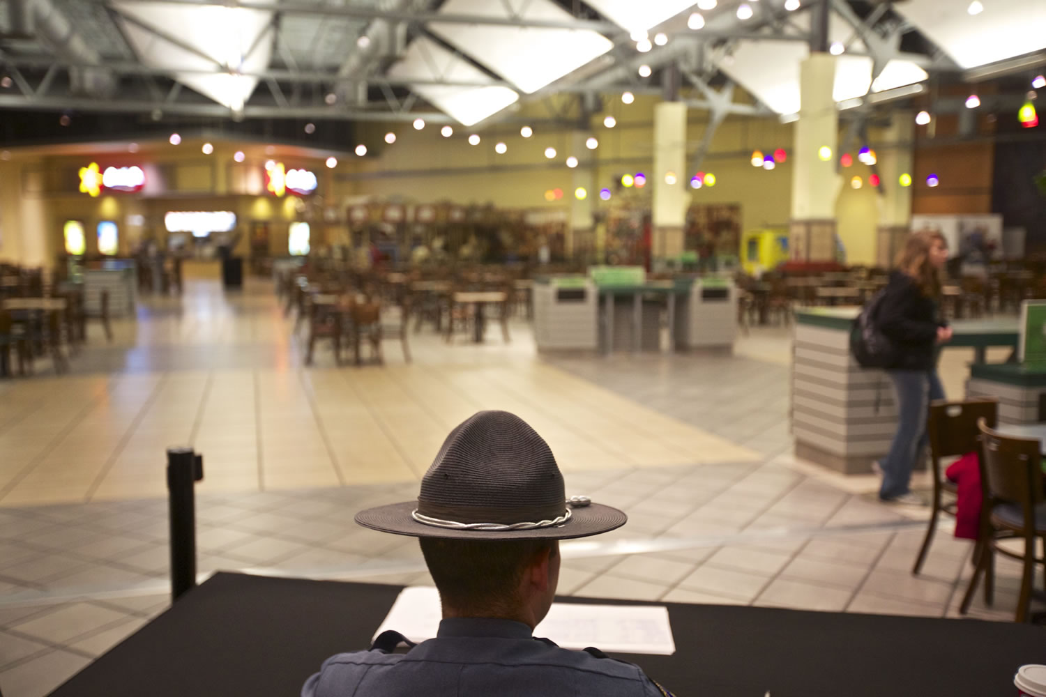 A security guard looks over the food court at the Clackamas Town Center mall as it opens, on Friday, Dec 14, 2012 in Portland, Ore. The mall is reopening, three days after a gunman killed two people and wounded a third amid a holiday shopping crowd estimated at 10,000. The shooter, Jacob Tyler Roberts, killed himself after the attack Tuesday afternoon.