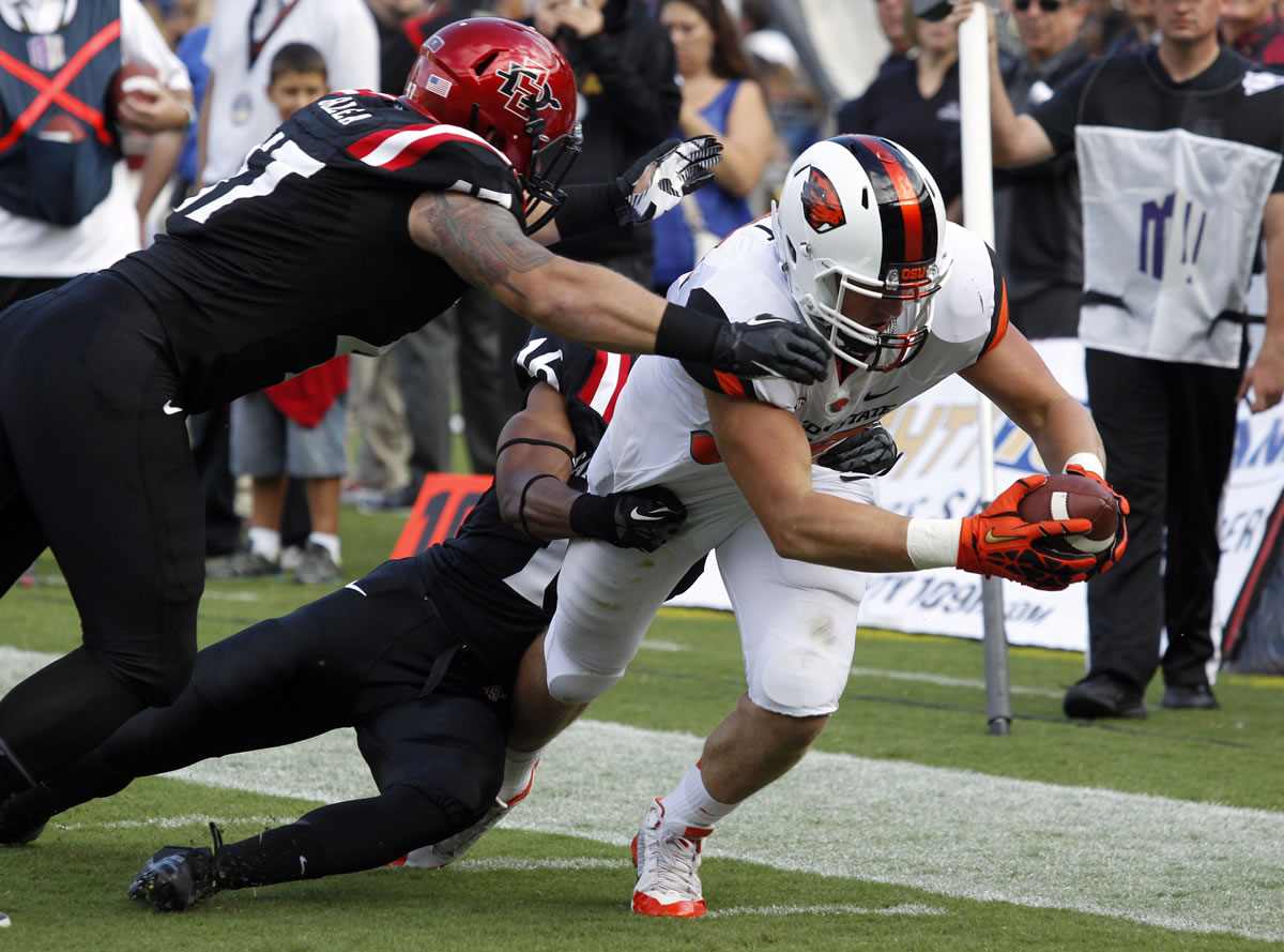 San Diego State defensive lineman Cody Galea, left, and defensive back David Lamar, stop Oregon State tight end Connor Hamlett, right, from scoring at the 1-yard line in the first half Saturday.