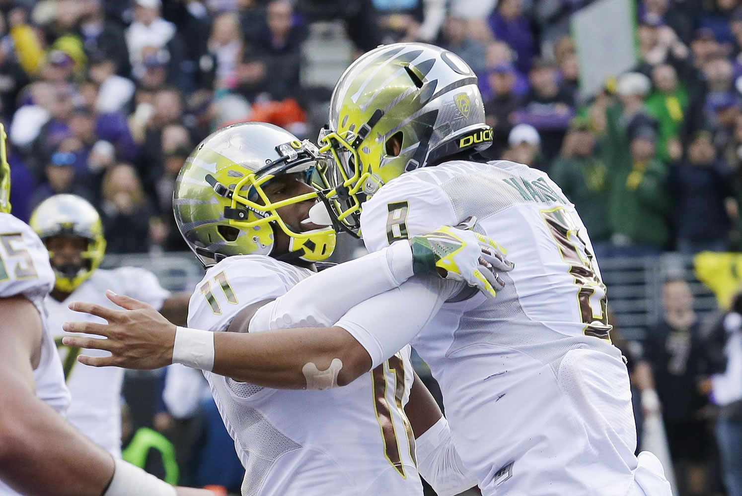 Oregon quarterback Marcus Mariota, right, celebrates with wide receiver Bralon Addison after Mariota scored a touchdown against Washington in the second half of an NCAA college football game, Saturday, Oct. 12, 2013, in Seattle. Oregon won 45-24. (AP Photo/Ted S.