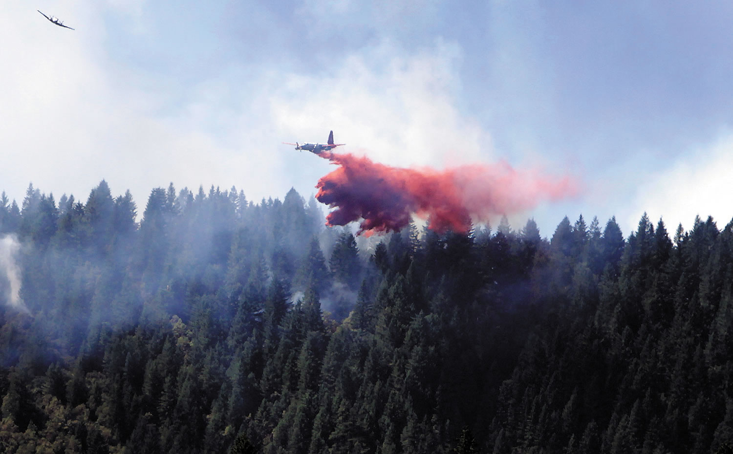 A fire-bomber and guide plane make a pass near Rattlesnake Creek in Glendale, Ore., on Sunday.