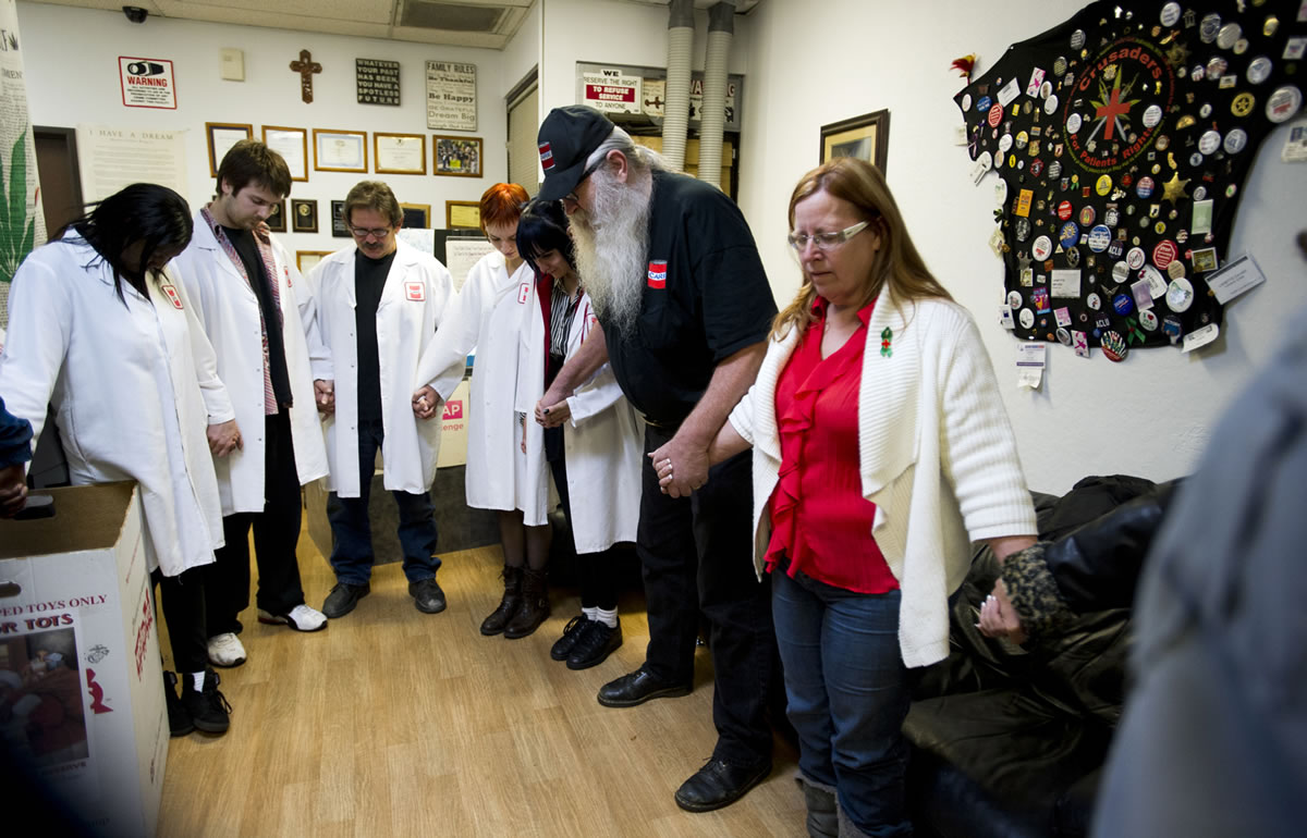 Paul Kitagaki Jr/Sacramento Bee
Bryan and Lanette Davies, right, join hands to lead a prayer each day at 6 p.m. for their staff and patients at the Canna Care marijuana dispensary in Sacramento, Calif.